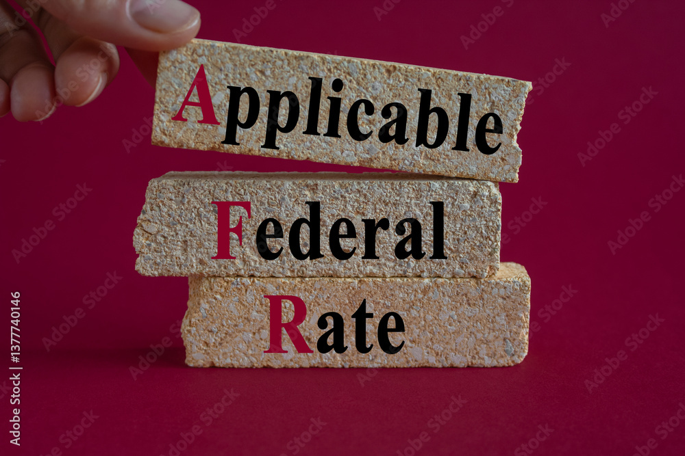 Applicable Federal Rate symbol. Concept words Applicable Federal Rate on brick blocks on a beautiful red background. Businessman hand. Business concept.