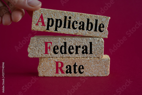 Obraz na płótnie Applicable Federal Rate symbol. Concept words Applicable Federal Rate on brick blocks on a beautiful red background. Businessman hand. Business concept. w salonie
