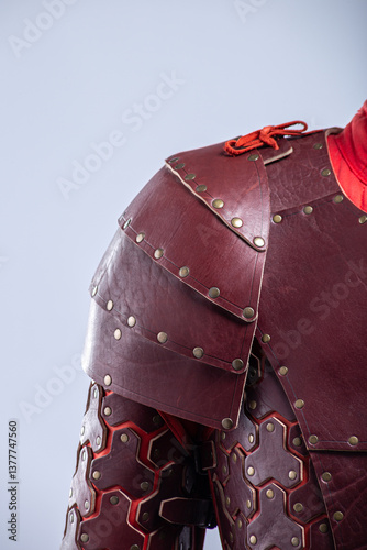 Close-up of Brown Leather Fantasy Shoulder Armor. Detailed view of the shoulder piece with rivets and red lacing.