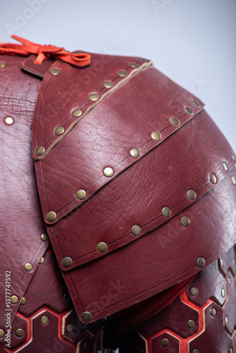 Close-up of Brown Leather Fantasy Shoulder Armor. Detailed view of the shoulder piece with rivets and red lacing.