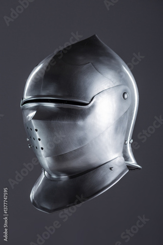 Polished Silver Medieval Armet Helmet with Perforated Visor. This shiny silver armet features a rounded skull, a protective bevor, and a visor with multiple small perforations.