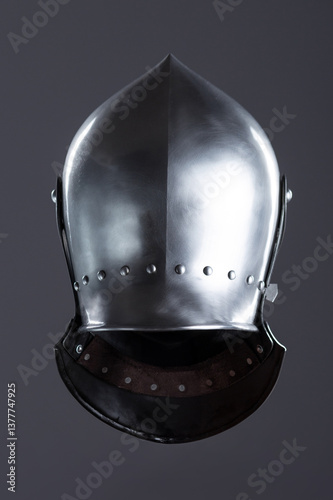 Polished Silver Medieval Armet Helmet with Perforated Visor. This shiny silver armet features a rounded skull, a protective bevor, and a visor with multiple small perforations.