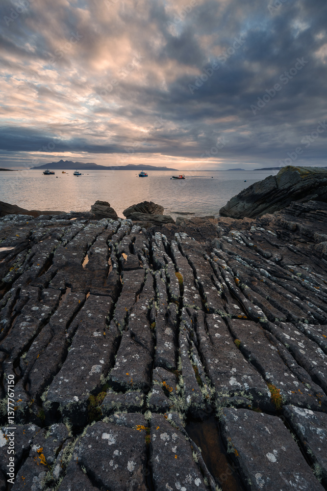 Dramatic waves crash against Elgol’s rugged coast, with the Cuillin Mountains rising in the misty distance. Autumn’s golden light enhances this wild, untamed beauty.