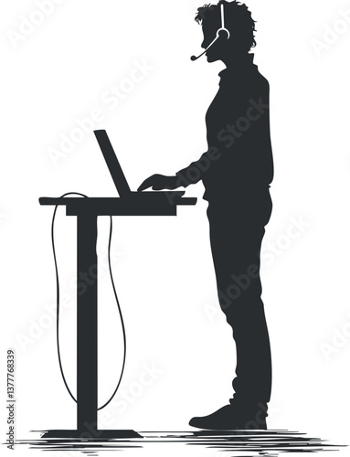 Silhouette of a man wearing a headset standing at a desk with a computer.