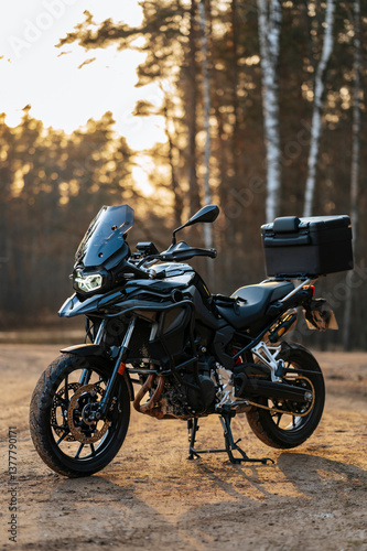 Black adventure motorcycle captured outdoors during sunset