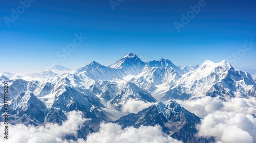 Experience the stunning aerial perspective of the Himalayas, where towering snow-covered peaks rise against a vibrant blue sky