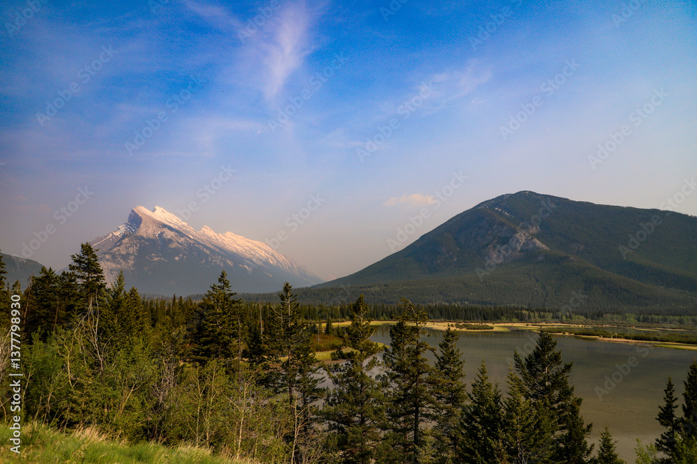 Obraz premium Mount Rundle and surrounding pine forest at sunrise reflecting on the Vermilion Lakes, Banff National Park, Canada