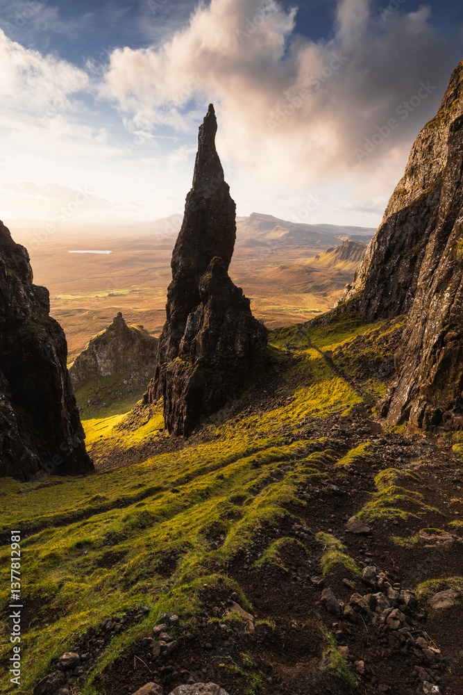 Autumn light bathes the Quiraing on Skye, casting long shadows over its dramatic cliffs and rolling hills. The landscape glows with golden hues, a breathtaking Highland scene.
