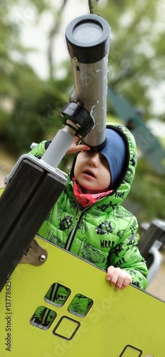 a boy looking through a telescope