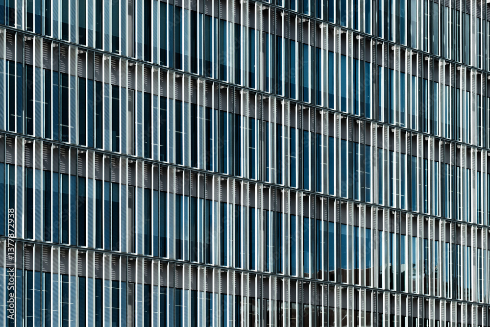 Blue-toned vertical louvers and glass on contemporary urban facade. Clean, modern and ideal for commercial projects related to architecture and real estate. Blue-toned vertical louvers and glass on contemporary urban facade. Clean, modern and ideal for commercial projects related to architecture and real estate.
