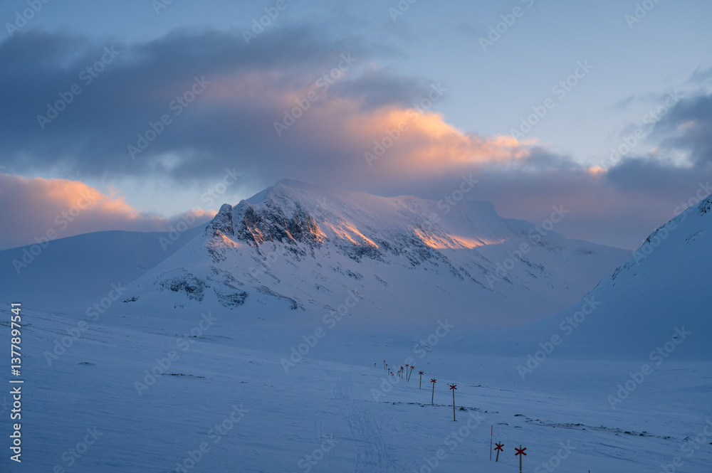 Marked trail for cross-country skiing toward mountain Templet, in the Sylarna mountain range during sunset.
