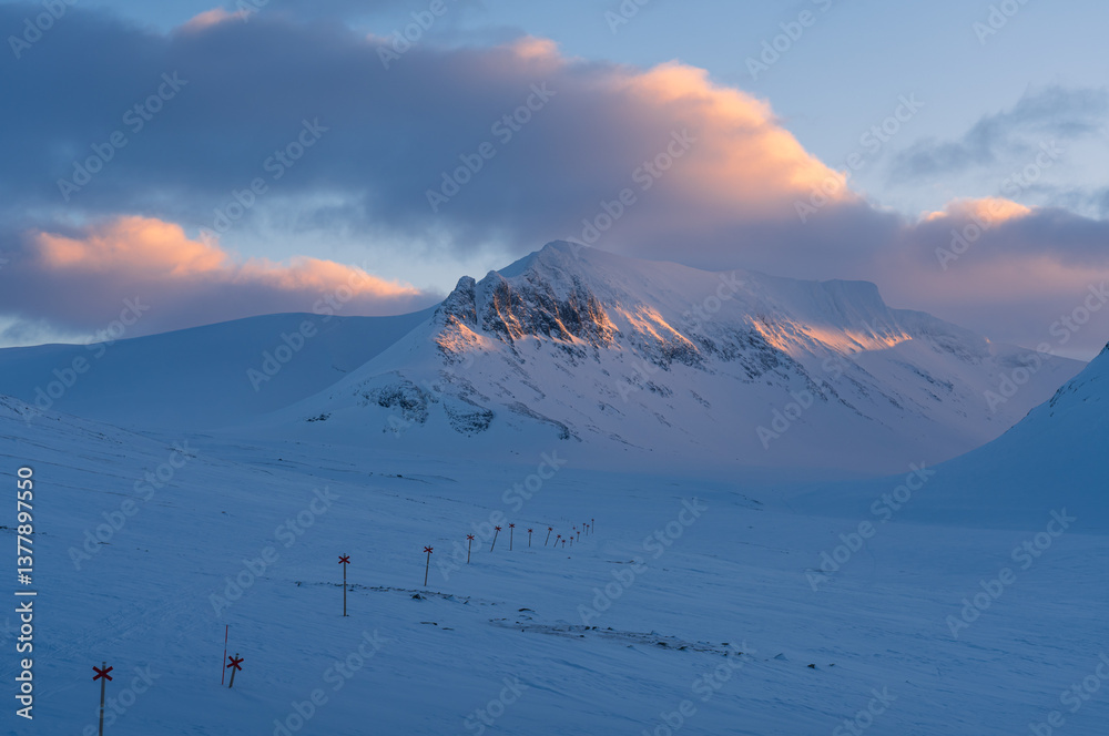 Marked trail for cross-country skiing toward mountain Templet, in the Sylarna mountain range during sunset.