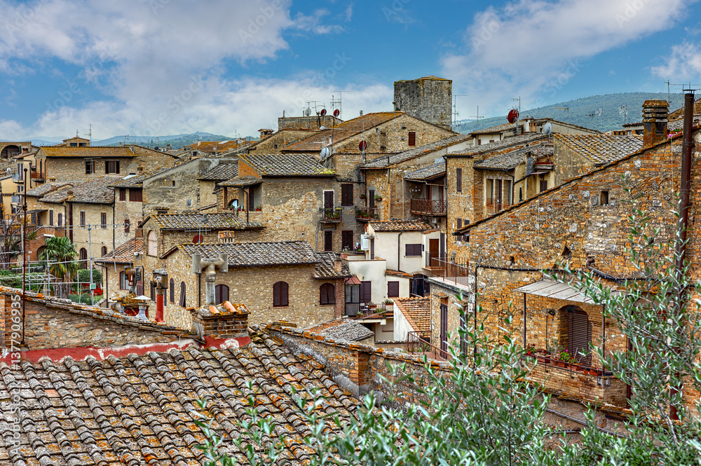 Charming rooftops of San Gimignano showcase medieval architecture nestled in Tuscany under a cloudy sky