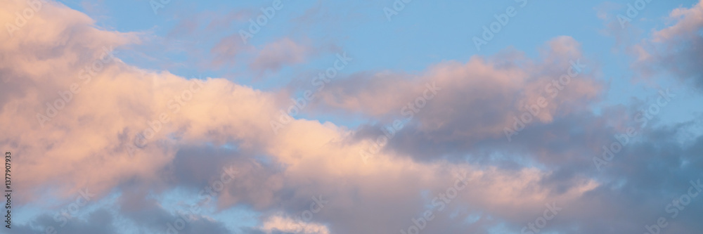 Beautiful sunset sky background with clouds. Scenic cloudscape. Wide panoramic background for design.