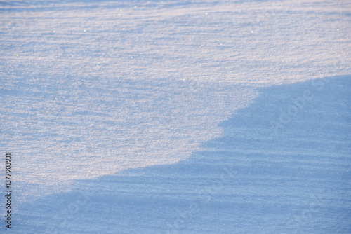 Obraz na płótnie Beautiful winter background with snowy ground. Natural snow texture. Wind sculpted patterns on snow surface. Closeup top view with copy space. w salonie