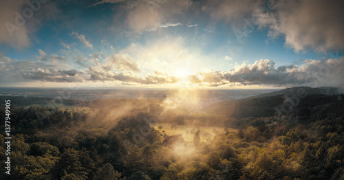 Obraz na płótnie Aerial panorama of a beautiful rural landscape at sunrise, with forest and meadow, nice clouds, great light and the mist illuminated by the morning sun w salonie