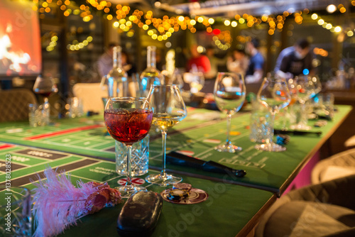 Casino party: poker chips, wine glasses, and a hat on a gaming table in an atmosphere of luxury and excitement