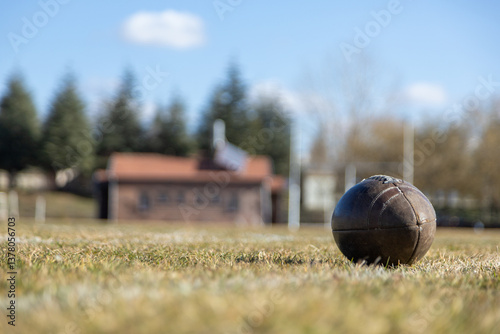 american football ball, worn american football ball and football field, grass and white lines, leather ball