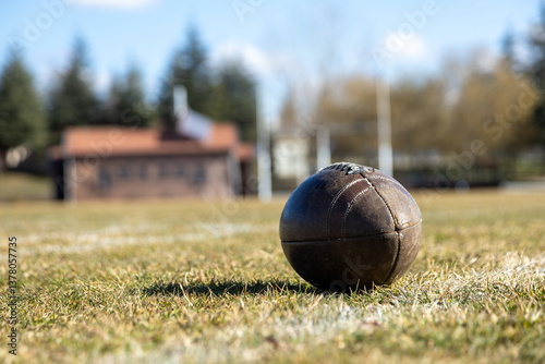 american football ball, worn american football ball and football field, grass and white lines, leather ball
