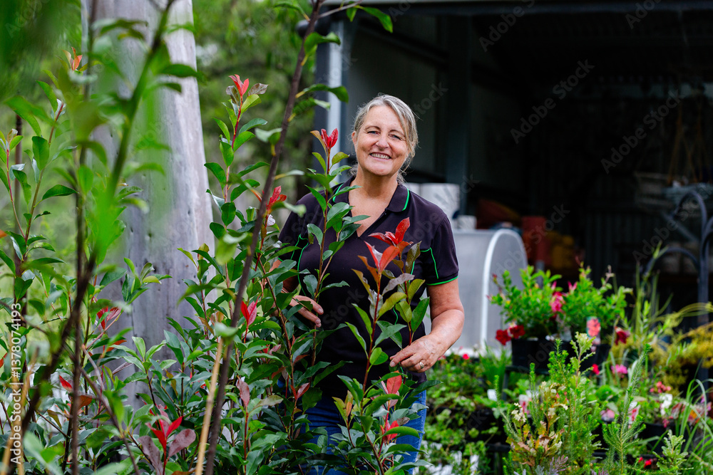 Happy Australian female horticulturalist smiling at camera in nursery garden