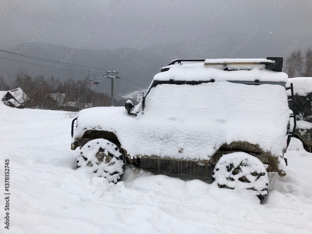 Snow covered off-road vehicle SUV car parked outdoor on a winter ski slope
