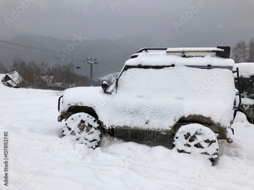 Obraz na płótnie Snow covered off-road vehicle SUV car parked outdoor on a winter ski slope w salonie