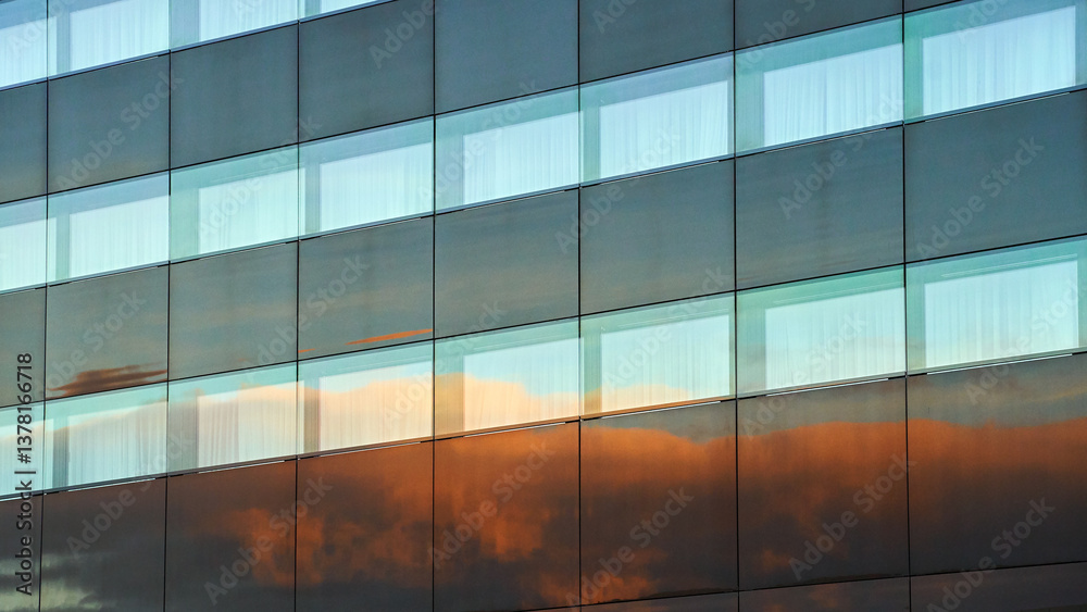 Evening clouds reflected in the modern building windows in a city background
