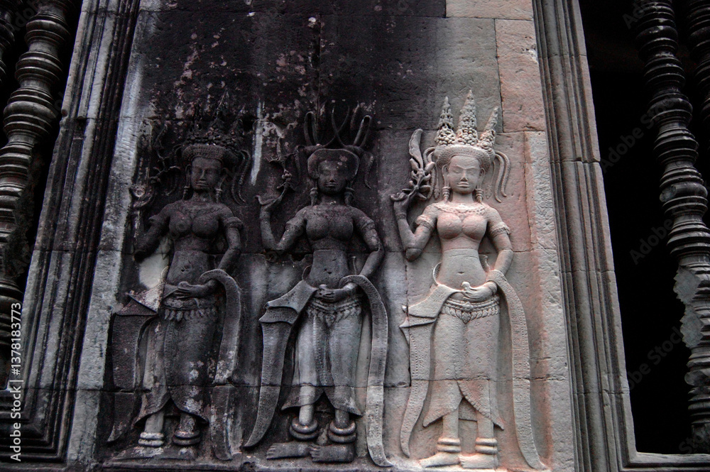Fototapeta premium Sculpture carving figure apsaras or apsara angel deity female spirit of clouds and waters elegant and superb art of dancing in Hindu and Buddhist culture on wall of Angkor wat at Siem Reap, Cambodia