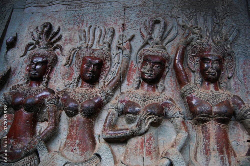 Naklejka premium Sculpture carving figure apsaras or apsara angel deity female spirit of clouds and waters elegant and superb art of dancing in Hindu and Buddhist culture on wall of Angkor wat at Siem Reap, Cambodia