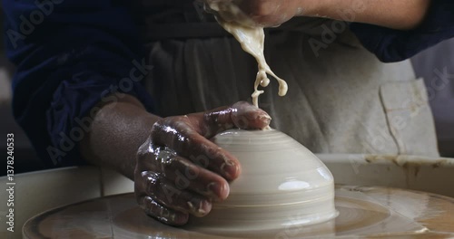 Super Slow Motion of Centering Clay on a Pottery Wheel While Water Drips from Above, a Potter's Hands Shape the Wet Form with Care and Pressure to Begin the Creative Process of Ceramic Craftsmanship