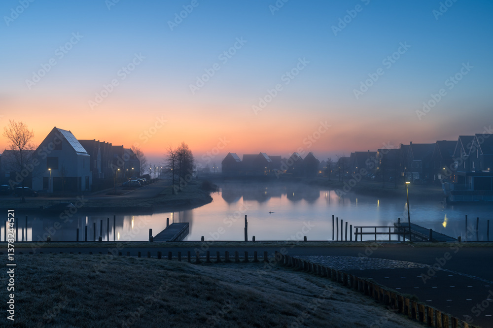 A tranquil, foggy dawn in a suburb at the waterfront in the Netherland. Meerstad.