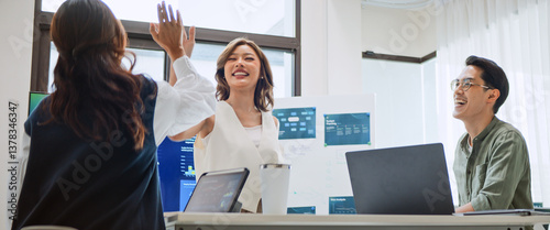 Group of Asian generation z business people work together in home office. Financial team businesspeople brainstorm meeting, team high-five clap hands celebrate success. Corporate teamwork concept