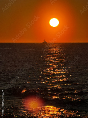 Obraz na płótnie Sunset over ocean with a boat and shimmering golden water w salonie