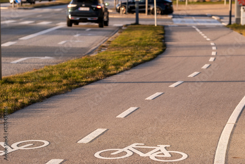 Curved bicycle path along road in Ørestad, Copenhagen. Clean urban design highlighting mobility, sustainability and safe cycling routes. photo