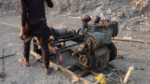 A diesel engine powering a winch, likely used for pulling or lifting heavy objects