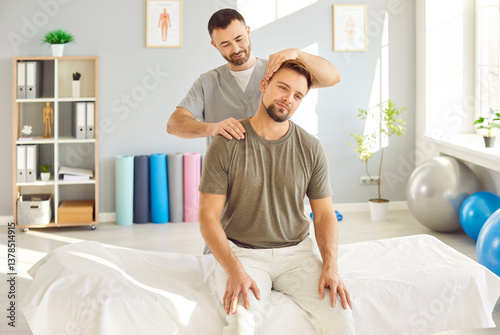 Professional chiropractor, osteopath or physiotherapist helping get rid of neck pain to young man patient who is sitting on medical massage bed at clinic