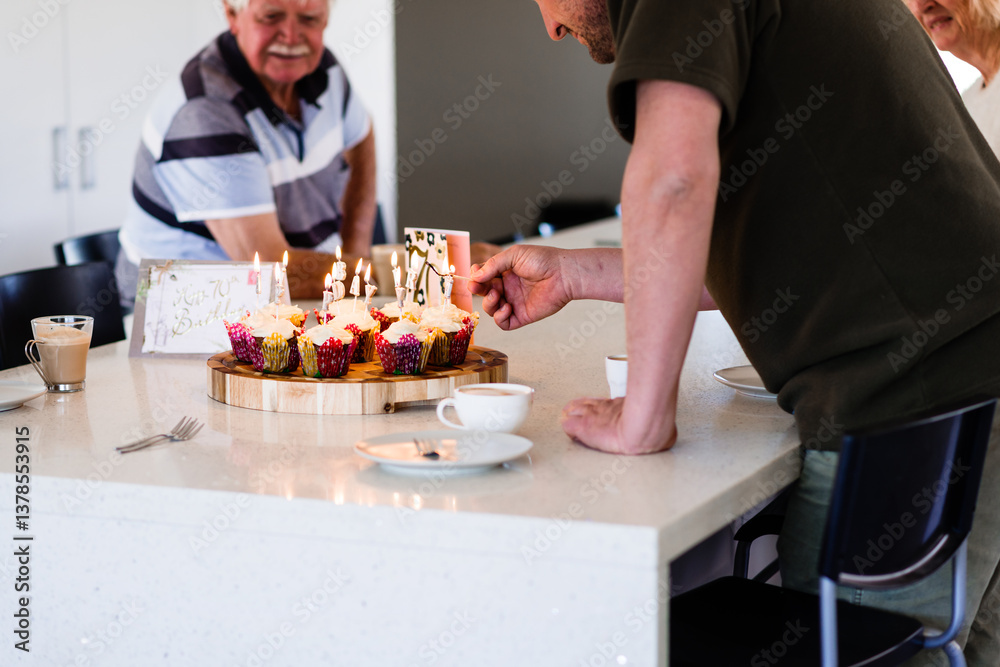 Man lighting candles on cupcakes for senior birthday party Man lighting candles on cupcakes for senior birthday party