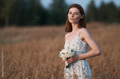 Portrait of a bride with a bouquet in a field