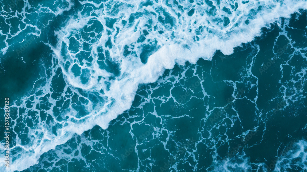 Fototapeta premium Aerial ocean waves crashing scene suitable for travel brochures, website banners, environmental conservation materials, and coastal tourism promotions.