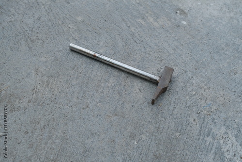 Photo of an iron hammer on the ground