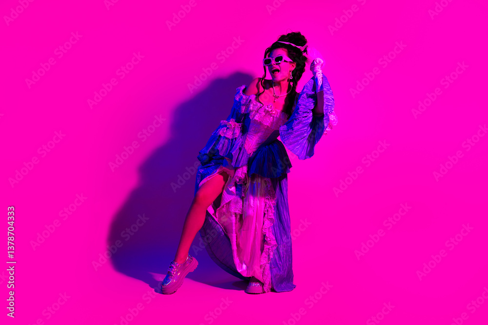 Fototapeta premium Young woman posing royally in historic-inspired attire with ultraviolet pink lighting