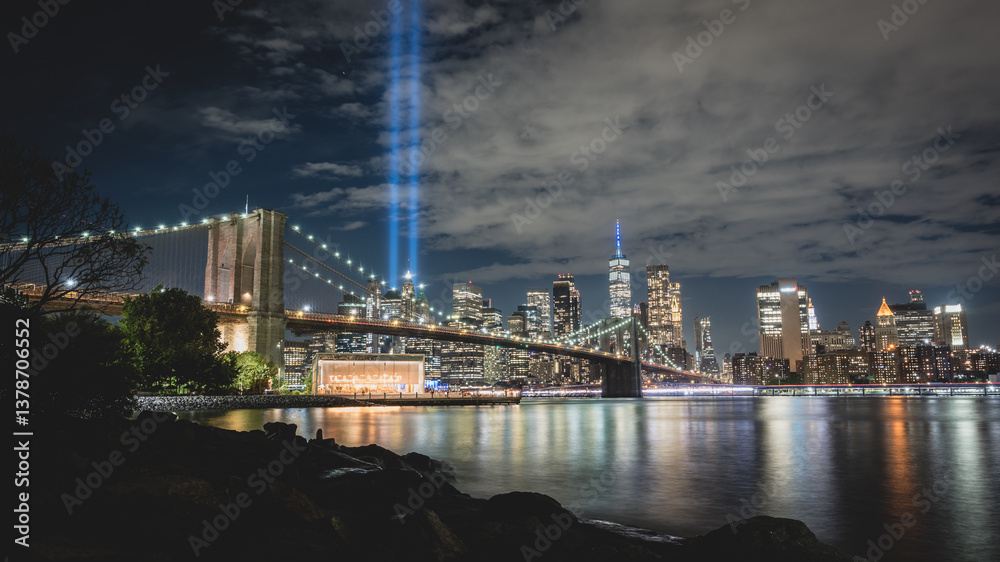 Fototapeta premium Night view during 9 11 of lower Manhattan and the Brooklyn Bridge with the Tribute in Light in the background