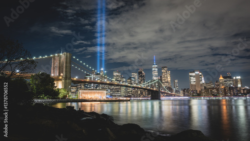Night view during 9 11 of lower Manhattan and the Brooklyn Bridge with the Tribute in Light in the background
