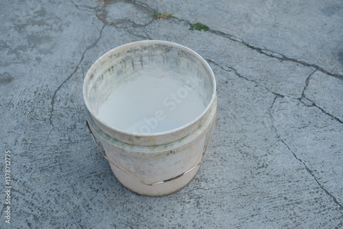 Photo of an empty white bucket on the ground
