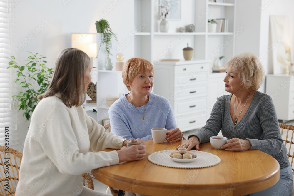 Obraz premium Friendship. Senior women enjoying hot drinks at table indoors