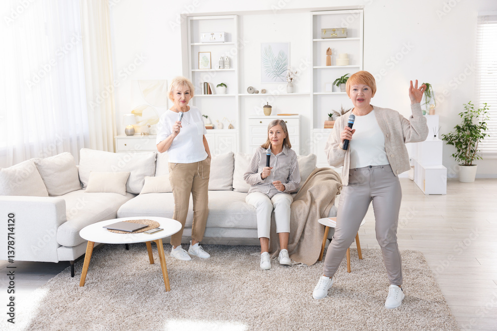 Obraz premium Senior woman singing karaoke with friends at home