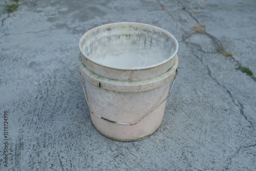 Photo of an empty white bucket on the ground