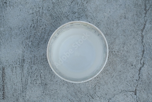 Photo of an empty white bucket on the ground
