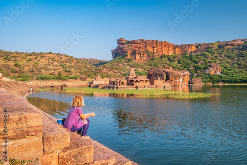 Obraz na płótnie Woman exploring ancient ruins at Badami. Tourist sitting on lake shore relaxing at Badami temple, Karnataka, India w salonie