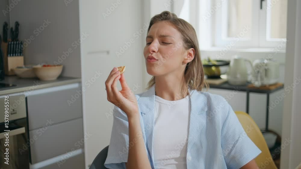Woman trying delicious food in home kitchen. Smiling girl in pajamas eating Woman trying delicious food in home kitchen. Smiling girl in pajamas eating